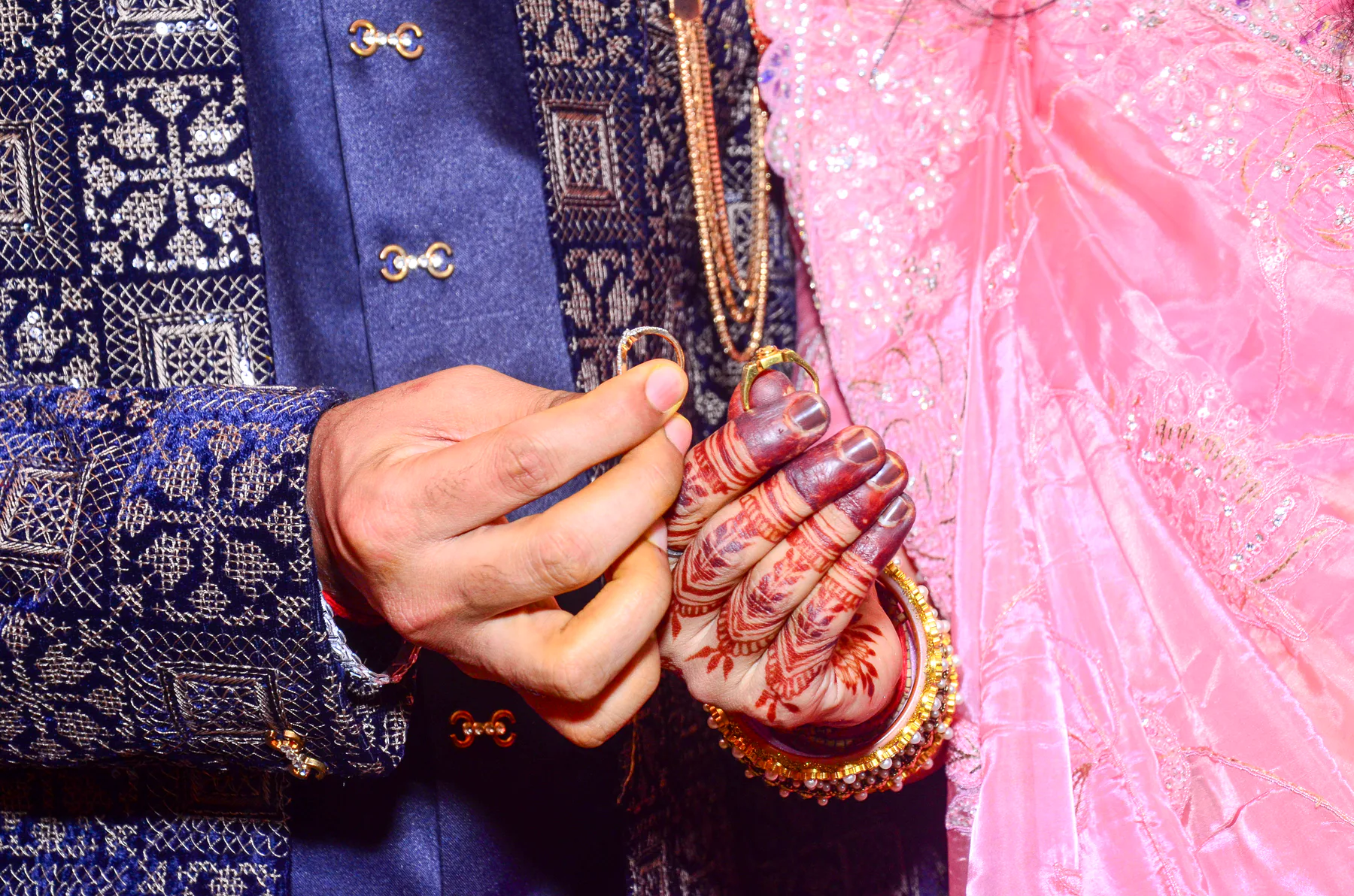 Close-up of engagement rings and henna