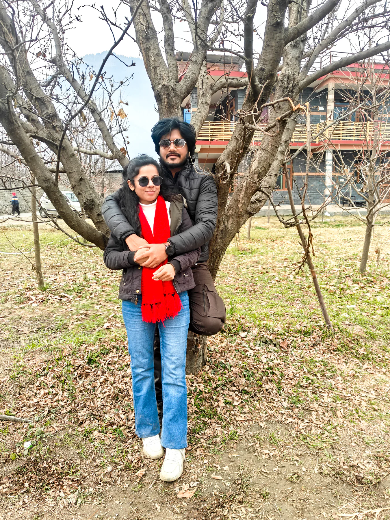 Pooja and Yuvaraj standing together near a tree